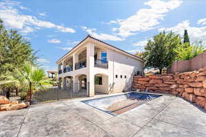 Back of property with a balcony, stucco siding, and a tile roof