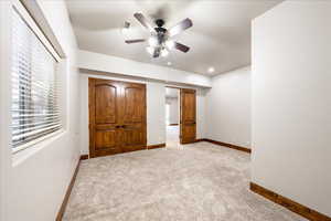 Unfurnished bedroom with carpet flooring and ceiling fan
