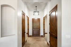 Hall with a chandelier and baseboards