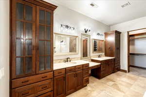Full bathroom with two vanities and baseboards