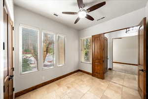 Unfurnished bedroom with ceiling fan and light tile patterned floors