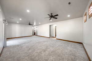 Spare room with a ceiling fan, light colored carpet, recessed lighting, and stairway