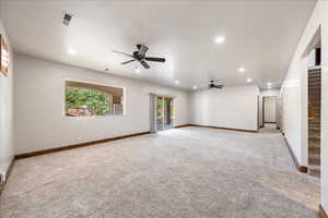 Unfurnished room featuring ceiling fan, stairway, light carpet, and recessed lighting