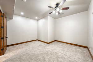 Carpeted empty room featuring ceiling fan and recessed lighting