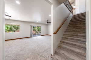 Staircase featuring carpet, ceiling fan, and recessed lighting
