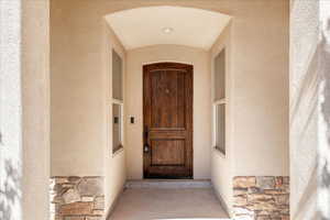 Property entrance featuring stone siding and stucco siding