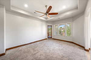 Unfurnished room with a tray ceiling, light colored carpet, ceiling fan, and recessed lighting