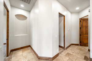 Hallway featuring recessed lighting and stone tile floors