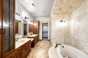 Full bath with a tub with jets and two vanities