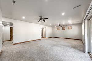 Spare room featuring light colored carpet, ceiling fan, and recessed lighting