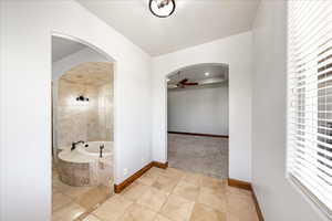 Full bathroom featuring a ceiling fan, a bath, tile patterned floors, recessed lighting, and a raised ceiling