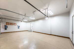 Garage featuring electric panel and a garage door opener