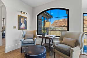 Sitting room with arched walkways, wood finished floors, and a mountain view