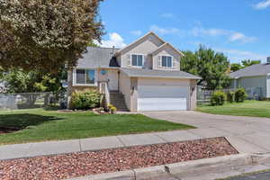 Split level home featuring concrete driveway, brick siding, an attached garage, and a shingled roof