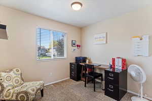 Carpeted office space featuring baseboards