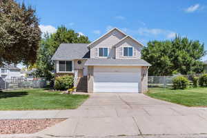 View of front of home with driveway, a garage, and brick siding