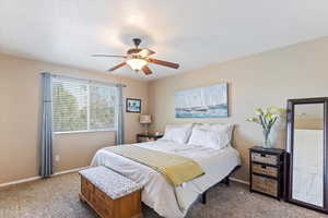 Bedroom featuring light colored carpet, ceiling fan, and a textured ceiling