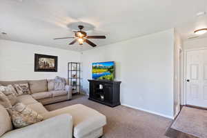 Living room with carpet flooring and a ceiling fan