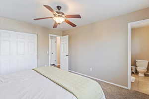 Bedroom featuring carpet floors, ensuite bath, tile patterned floors, and ceiling fan