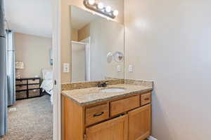 Full bathroom with connected bathroom, vanity, and a stall shower