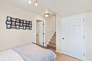 Bedroom with light colored carpet and baseboards
