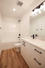 Full bathroom with vanity, wood finished floors, and  shower combination