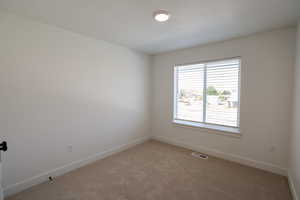 Unfurnished room featuring light colored carpet and baseboards