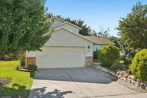 View of front of home featuring brick siding, concrete driveway, an attached garage, and roof with shingles