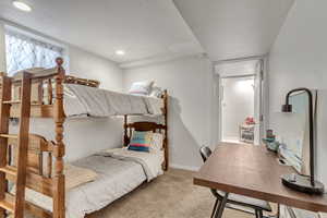 Carpeted bedroom with baseboards and a textured ceiling