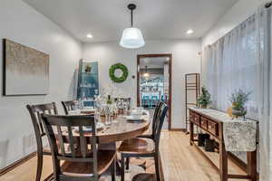 Dining room with light wood-style flooring and recessed lighting