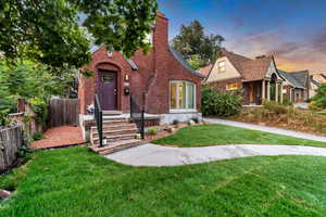 English style home with a chimney and brick siding