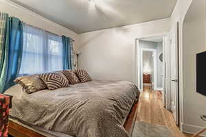 Bedroom featuring light wood-type flooring and ornamental molding