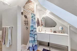 Full bathroom featuring a shower stall, vanity, and tile patterned floors