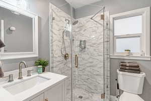 Full bathroom featuring vanity and a marble finish shower