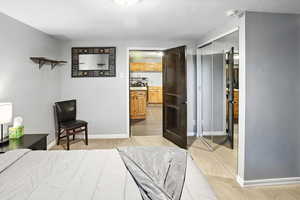 Bedroom featuring a textured ceiling, a closet, and ensuite bath