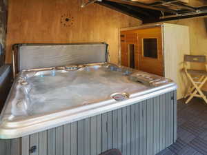 Miscellaneous room with a hot tub and wood walls