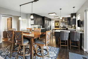 Dining area with dark wood-type flooring and baseboards
