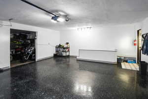 Garage with baseboards and a garage door opener