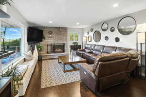 Living area with dark wood-type flooring, a fireplace, and recessed lighting