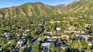 Aerial view of property and surrounding area with nearby suburban area and a mountainous background