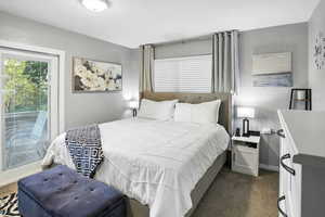 Bedroom with dark carpet and access to outside