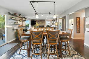 Dining area with dark wood finished floors and rail lighting