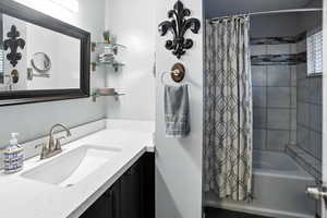 Bathroom with shower / tub combo with curtain and vanity