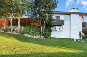 Back of property with brick siding, a balcony, and a chimney