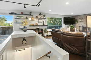 Living area with dark wood-style floors and recessed lighting
