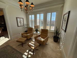 Living area with a chandelier and ornamental molding