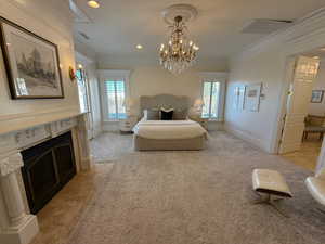 Bedroom with multiple windows, crown molding, recessed lighting, a fireplace, and a chandelier