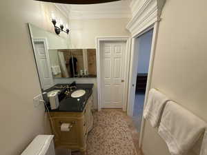 Bathroom with ornamental molding and vanity