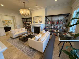 Living room with crown molding, recessed lighting, a chandelier, a fireplace, and tile patterned flooring