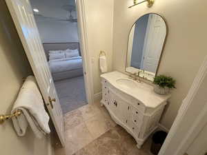 Ensuite bathroom featuring vanity, a ceiling fan, crown molding, and tile patterned flooring